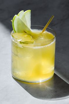 a close up of a drink in a glass with a lime slice on the rim