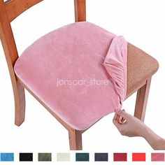 a pink chair with a pillow on it and a hand reaching for the seat cushion