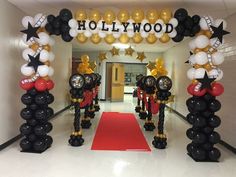 an entrance decorated with black, white and gold balloons for hollywood birthdays or baby showers