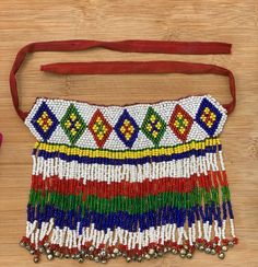 the beaded purse is sitting on top of a wooden table