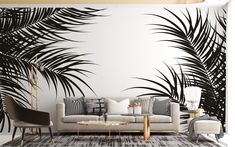 a living room with black and white palm leaves on the wall