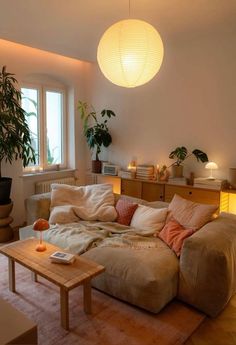 a living room filled with lots of furniture and plants on top of the table in front of a window