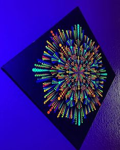 a colorful art piece is displayed on the wall in front of a purple background with blue and green colors