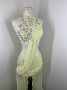 a mannequin dressed in a white dress with silver beadings on it