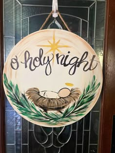 a door hanger with a nativity sign hanging from it's glass front