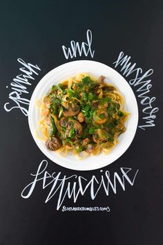 a white plate topped with pasta and meat covered in sauce on top of a black table