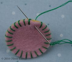 a pink and green object with two needles