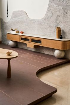 a living room with two tables and a large mirror on the wall above it's shelf