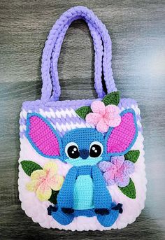 a crocheted bag with an elephant on the front and flowers on the back