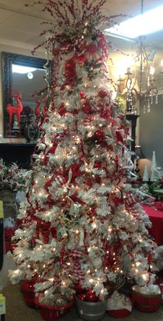 a white christmas tree with red and silver decorations