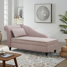 a pink chaise lounger in a living room with rug and potted plant