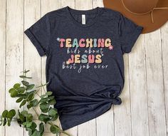 Inspire faith in our "Teaching Kids about Jesus" shirt - a must-have for ministry leaders, ministers, and youth pastors. Elevate your impact in children's ministry with this Christian tee, a blend of comfort and purpose. Make a statement of devotion with our Church Shirt, designed to spark conversations and share the joy of spreading the teachings of Jesus. Embrace the calling with style and comfort - an ideal addition to your ministry wardrobe. This classic unisex jersey short sleeve tee fits l Childrens Ministry Shirts, Raising Disciples Shirt, Scripture Shirt For Kids, Short Sleeve T-shirt For Daycare, Christian Kids Shirts