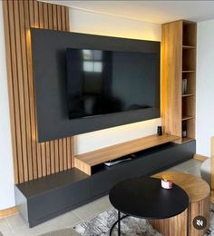 a living room with a large television mounted on the wall