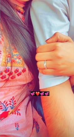 a close up of a person wearing a ring and holding another person's arm