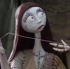 a creepy doll holding a string with her hands