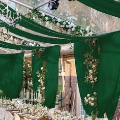 the tables are covered with green draping and white flowers