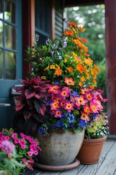 two potted plants sitting on top of a wooden floor next to each other with flowers growing out of them