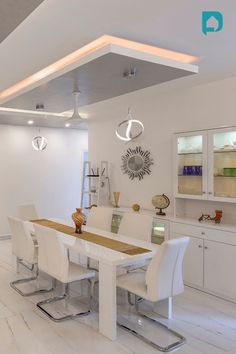 a modern dining room with white furniture and lighting