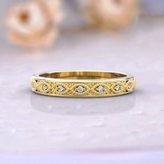 a gold wedding band with diamonds on it