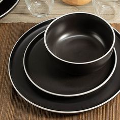 black and white dinnerware is set on a place mat