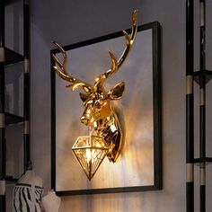 a golden deer head mounted on the wall next to a lamp and zebra print rug