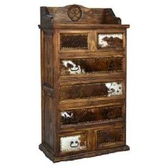 an old wooden dresser with cow hides on the top and bottom drawers in it