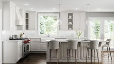 a kitchen with white cabinets and bar stools next to an island in the middle