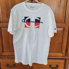 Up For Sale Is A Stylish White T-Shirt From Champion In Size Medium. This Shirt Is Perfect For Any Casual Occasion And Is Made With High-Quality Materials To Ensure Long-Lasting Comfort. The Brand Name Speaks For Itself And You'll Be Sure To Turn Heads In This Fashionable Piece. It's A Great Addition To Any Wardrobe And Can Be Worn With Jeans Or Shorts. Get Your Hands On This Nwot Item Before It's Gone! Armpit To Armpit 21 Inches Shoulder To Bottom Hem 30 Inches Smoke Free Home. Make Me An Offer White Crew Neck Shirt With Logo Print, White Tshirt, Brand Names, Red And White, Tee Shirts, Mens Shirts, Man Shop, Wardrobe, White