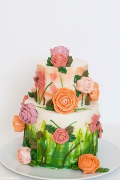 a three tiered cake with flowers painted on it