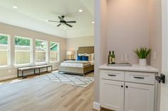 a bedroom with white walls and wood flooring next to a bed in a room