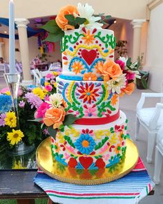 a multi - tiered cake decorated with flowers and hearts