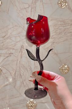 a hand holding a wine glass that is shaped like a flower