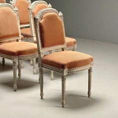 a set of six chairs sitting next to each other on top of a white floor