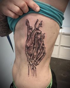 a person with a tattoo on their stomach that has an image of a human heart