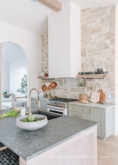 a kitchen with an island and stone walls