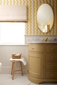 a white toilet sitting next to a bathroom sink under a mirror on top of a counter