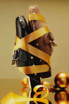 a pair of shoes wrapped in yellow ribbon next to an ornament and ball