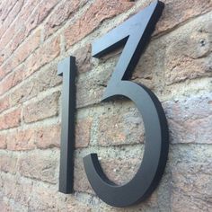 the number five is mounted to the side of a brick building with black metal numbers on it