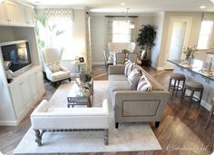 a living room filled with furniture and a flat screen tv on top of a wooden floor