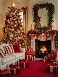 a living room decorated for christmas with red and white presents on the floor next to a fire place