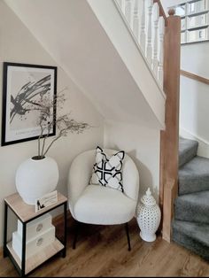 a white chair sitting under a stair case