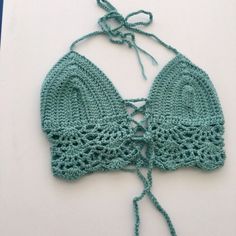 This top will best fit a size xsmall/small. It was made with soft acrylic worsted weight yarn. It ties around the neck as well as behind the back & has one tie criss crossing in the middle of the chest - which can be tied any way & loosens and tightens the top as well. Knit Crochet Trim Crop Top For Beach, Beach Knit Fitted Halter Top, Beach Fitted Knit Halter Top, Fitted Knit Halter Top For The Beach, Fitted Crochet Cotton Top For Beach, Fitted Crochet Top In Cotton Yarn For Beach, Fitted Cotton Crochet Top For Beach, Fitted Cotton Yarn Crochet Top For Beach, Beach Cotton Open Knit Crop Top