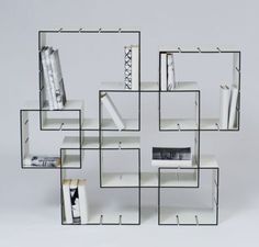 a white book shelf with books and magazines on it's shelves in the shape of cubes