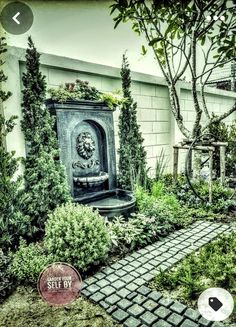 an outdoor garden with plants and a clock