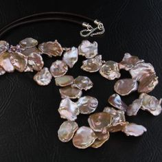 Keshi Pearl Necklace in beautiful  BLUSH PINK also called Keshi Petal Pearls or Corn Flake Pearls(Natural Color) strung with silk thread interspersed with tiny Silver beads. This long necklace is finished with leather cord with all Silver Findings and Silver Clasp. Keshi "meaning poppy " pearls do not have a nucleus and are a by-product of  the cultivation of cultured Pearls. Materials: Size of the individual Pearls - 18mm - 20mm How to take Care of your Pearls: Pearls are formed organically and Elegant Shell-shaped Pearl Necklace For Gifting, Pink Baroque Pearl Necklace For Wedding, Pink Baroque Pearl Necklace With Pendant, Luxury Pink Baroque Pearl Necklace, Corn Flake, Keshi Pearl Necklace, Pearl Necklace Wedding, Wedding Gifts For Bridesmaids, Hair Spray