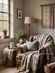 a plaid blanket is draped over the arm of a chair in a living room with two wicker baskets