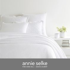 an image of a bed with white sheets and pillows in the room that says annie selke