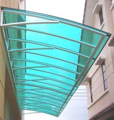 an empty street is lined with tall buildings and glass awnings on the sides