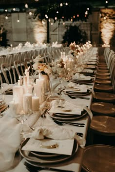 the table is set with candles, plates and napkins for an elegant wedding reception