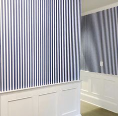 an empty room with blue and white striped walls